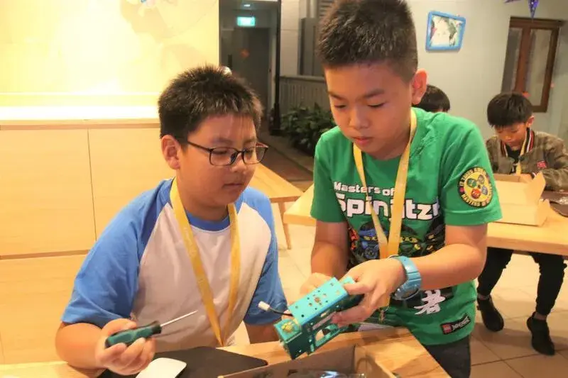 Two boys collaborating on robot assembly at CodeFest