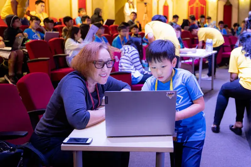 Judge mentoring young participant at CodeFest