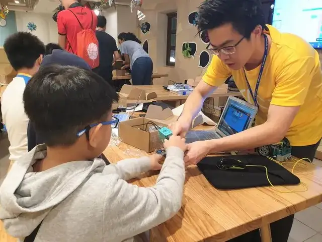 Mentor helping student build robot at CodeFest workshop