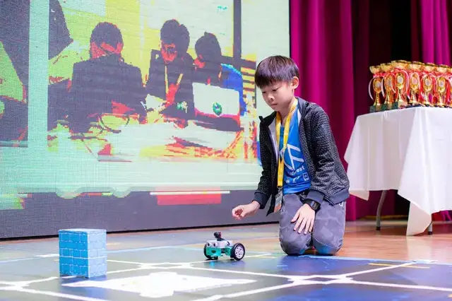 Student demonstrating robot on stage at CodeFest