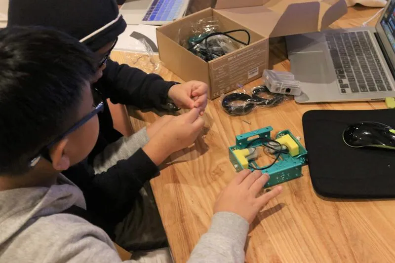 Students assembling robot components at CodeFest