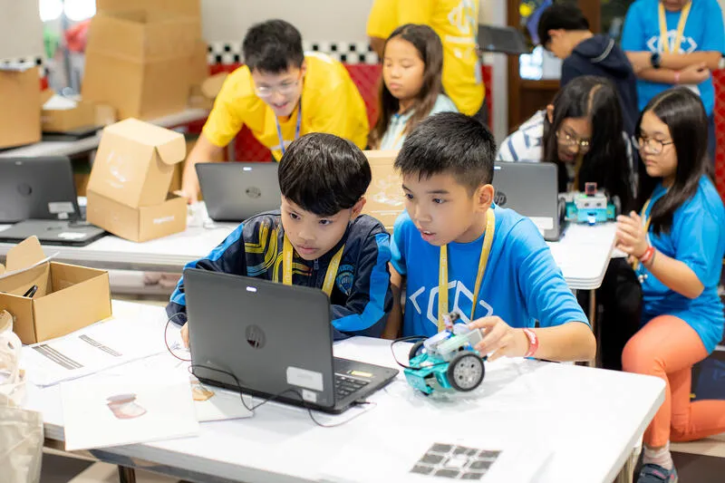 Students building robots with mentors at CodeFest