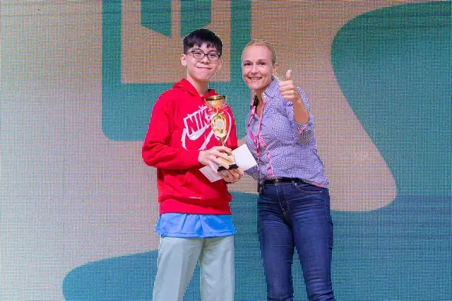 CodeFest teen winner holding trophy with thumbs up