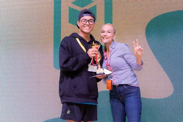 CodeFest winner posing with trophy and peace sign