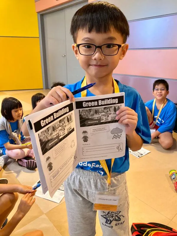 Young coder showing Green Building worksheet at CodeFest