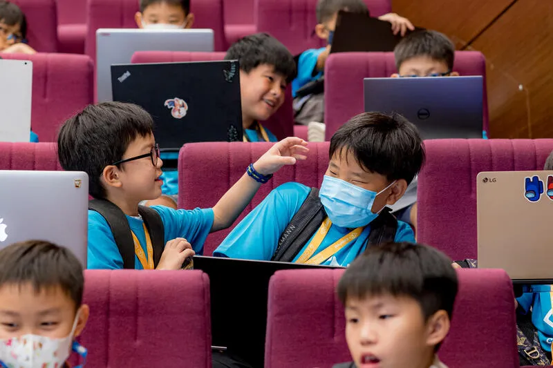 Kids collaborating on laptops at CodeFest