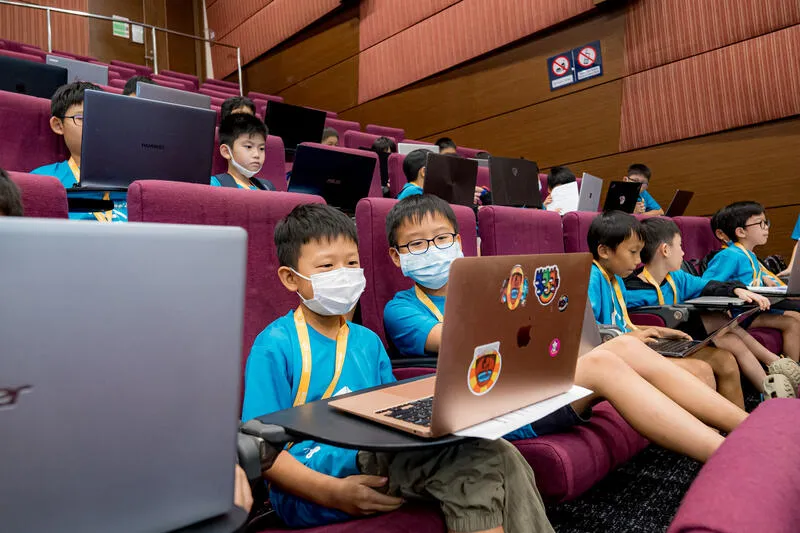 Kids working on laptops at CodeFest hackathon